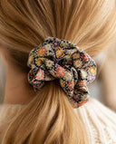 Close-up of the Black Floral Medley kimono scrunchie worn on a low ponytail