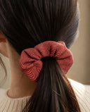 Close-up of the Rose Red Pinstripe kimono scrunchie worn on a low ponytail