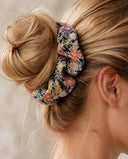 Close-up of the Black Floral Medley kimono scrunchie worn on a messy bun