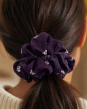 Close-up of the Purple Falling Petals kimono scrunchie worn on a low ponytail