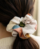 Close-up of the Ivory Watercolor kimono scrunchie worn on a low ponytail