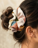 Close-up of the Ivory Watercolor kimono scrunchie worn on a messy bun
