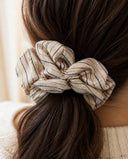 Close-up of the Cream Pinstripe kimono scrunchie worn on a low ponytail