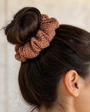 Close-up of the Copper Shibori kimono scrunchie worn on a messy bun