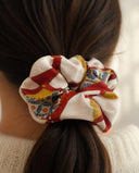 Close-up of the Ivory & Crimson Bold Motif kimono scrunchie worn on a low ponytail