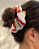 Close-up of the Ivory & Crimson Bold Motif kimono scrunchie worn on a messy bun