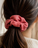 Close-up of the Coral Red Shimmer kimono scrunchie worn on a low ponytail