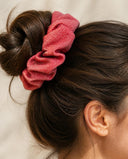 Close-up of the Coral Red Shimmer kimono scrunchie worn on a messy bun