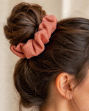 Close-up of the Salmon Shimmer kimono scrunchie worn on a messy bun
