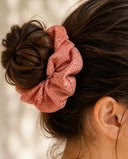 Close-up of the Coral Gold Fleck kimono scrunchie worn on a messy bun
