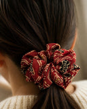 Close-up of the Crimson & Gold Motif kimono scrunchie worn on a low ponytail