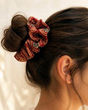 Close-up of the Crimson & Gold Motif kimono scrunchie worn on a messy bun