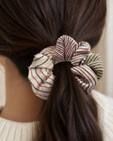 Close-up of the Cream & Rose Stripe kimono scrunchie worn on a low ponytail