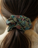 Close-up of the Teal Floral Medley kimono scrunchie worn on a low ponytail