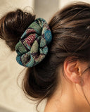 Close-up of the Teal Floral Medley kimono scrunchie worn on a messy bun