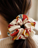 Close-up of the Ivory & Crimson Floral kimono scrunchie worn on a low ponytail