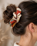 Close-up of the Ivory & Crimson Floral kimono scrunchie worn on a messy bun
