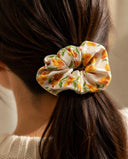 Close-up of the Cream & Orange Floral kimono scrunchie worn on a low ponytail