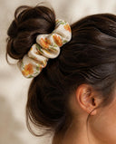 Close-up of the Cream & Orange Floral kimono scrunchie worn on a messy bun