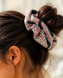 Close-up of the Pink Ditsy Floral kimono scrunchie worn on a messy bun