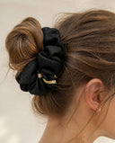 Close-up of the Black Gold Fleck kimono scrunchie worn on a messy bun