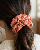 Close-up of the Orange Chrysanthemum kimono scrunchie worn on a low ponytail