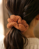 Close-up of the Orange Kanoko Shibori kimono scrunchie worn on a low ponytail
