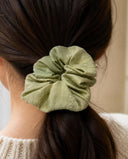 Close-up of the Sage Green kimono scrunchie worn on a low ponytail